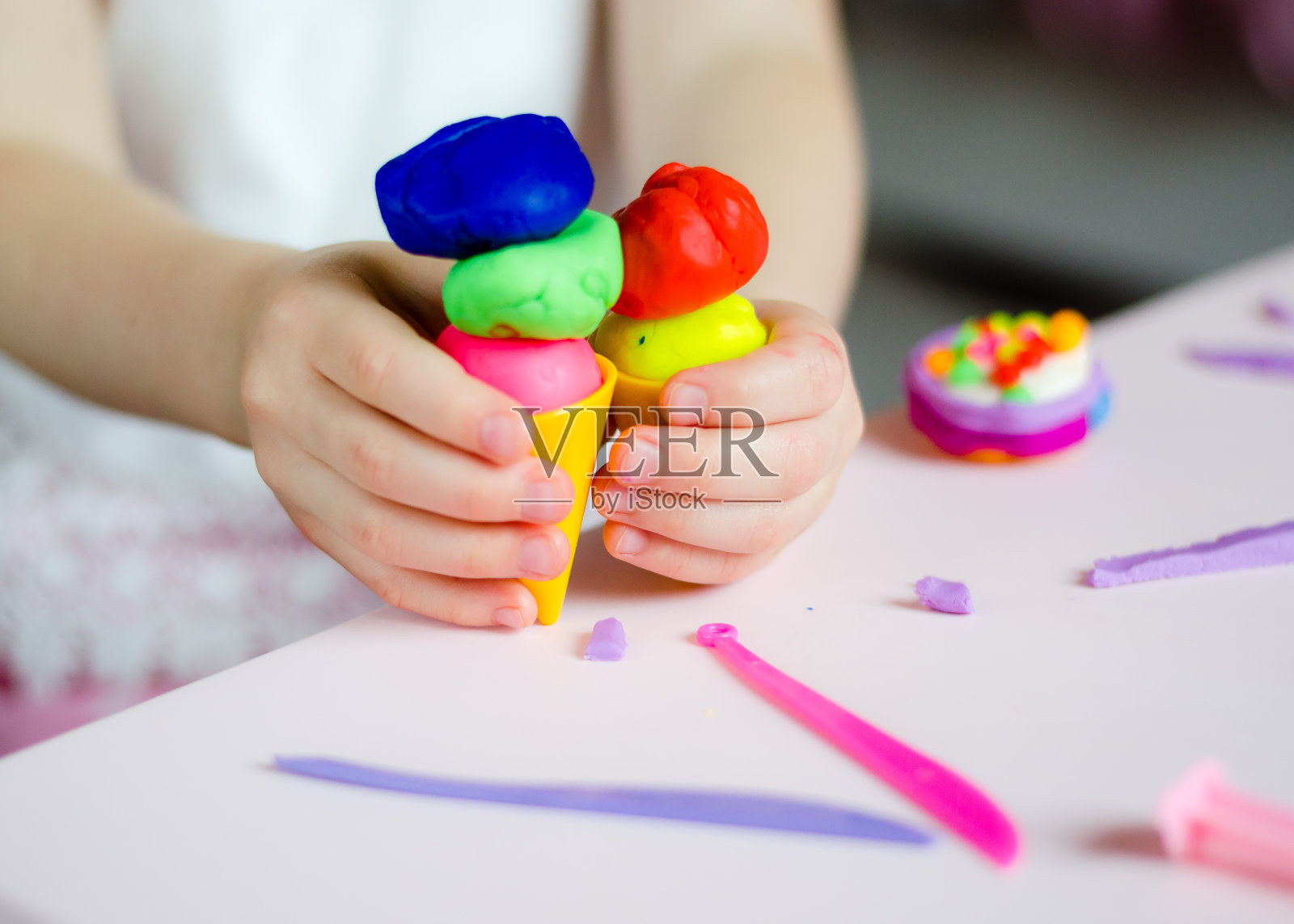 孩子的手玩着彩色的粘土。自制plastiline。橡皮泥。玩面团。少女造型粘土。自制的粘土。照片摄影图片