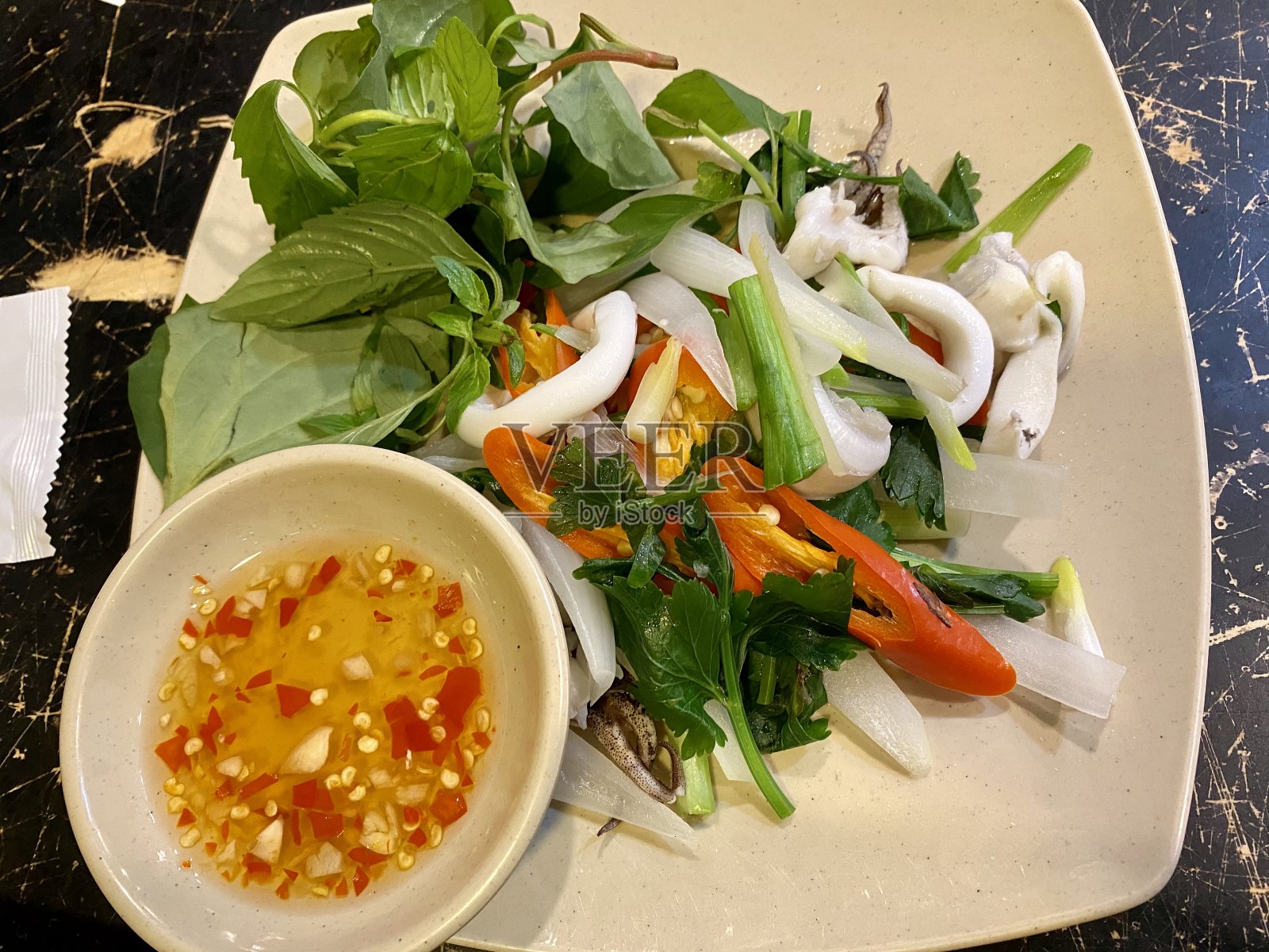 越南街头小吃清蒸鱿鱼配葱花蘸酱照片摄影图片