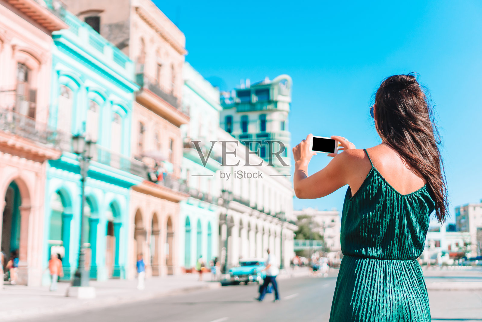 在古巴哈瓦那的热门地区旅游的女孩。年轻的女旅行者快乐地微笑着。照片摄影图片