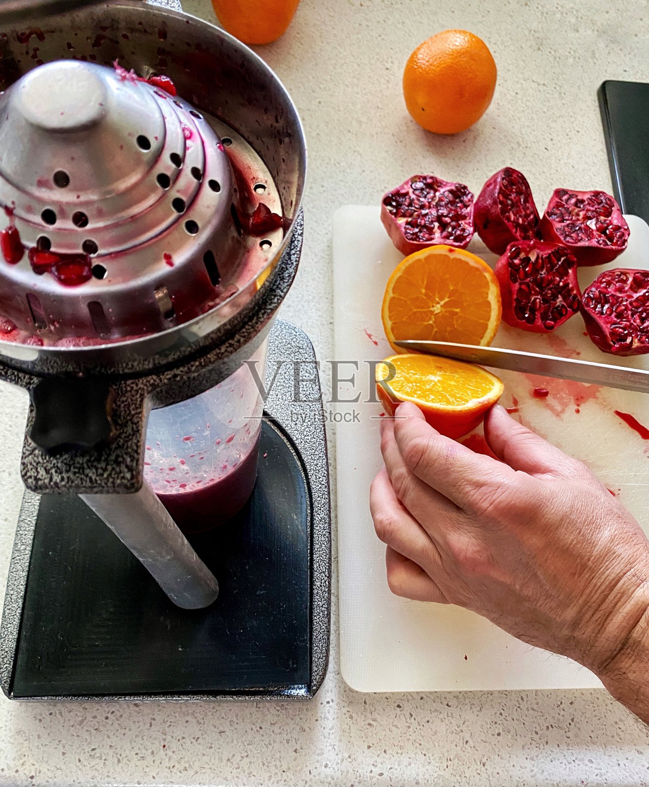 用机械榨汁机榨取橙汁和石榴汁的过程照片摄影图片