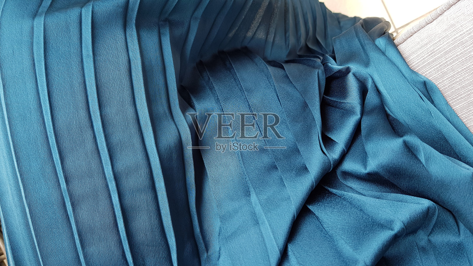 褶皱织物纹理的蓝色条纹纺织品特写。带有褶边和条纹的休闲服褶皱。时尚背景与复制空间。照片摄影图片