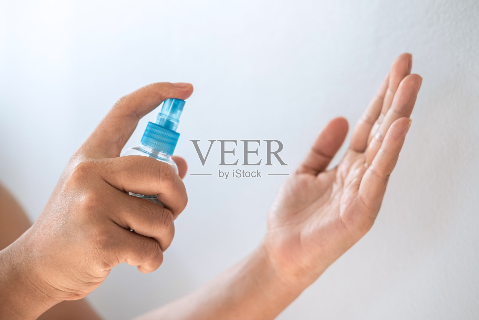 妇女用酒精喷雾洗手，清洁双手，预防和消毒冠状病毒和其他病毒照片摄影图片