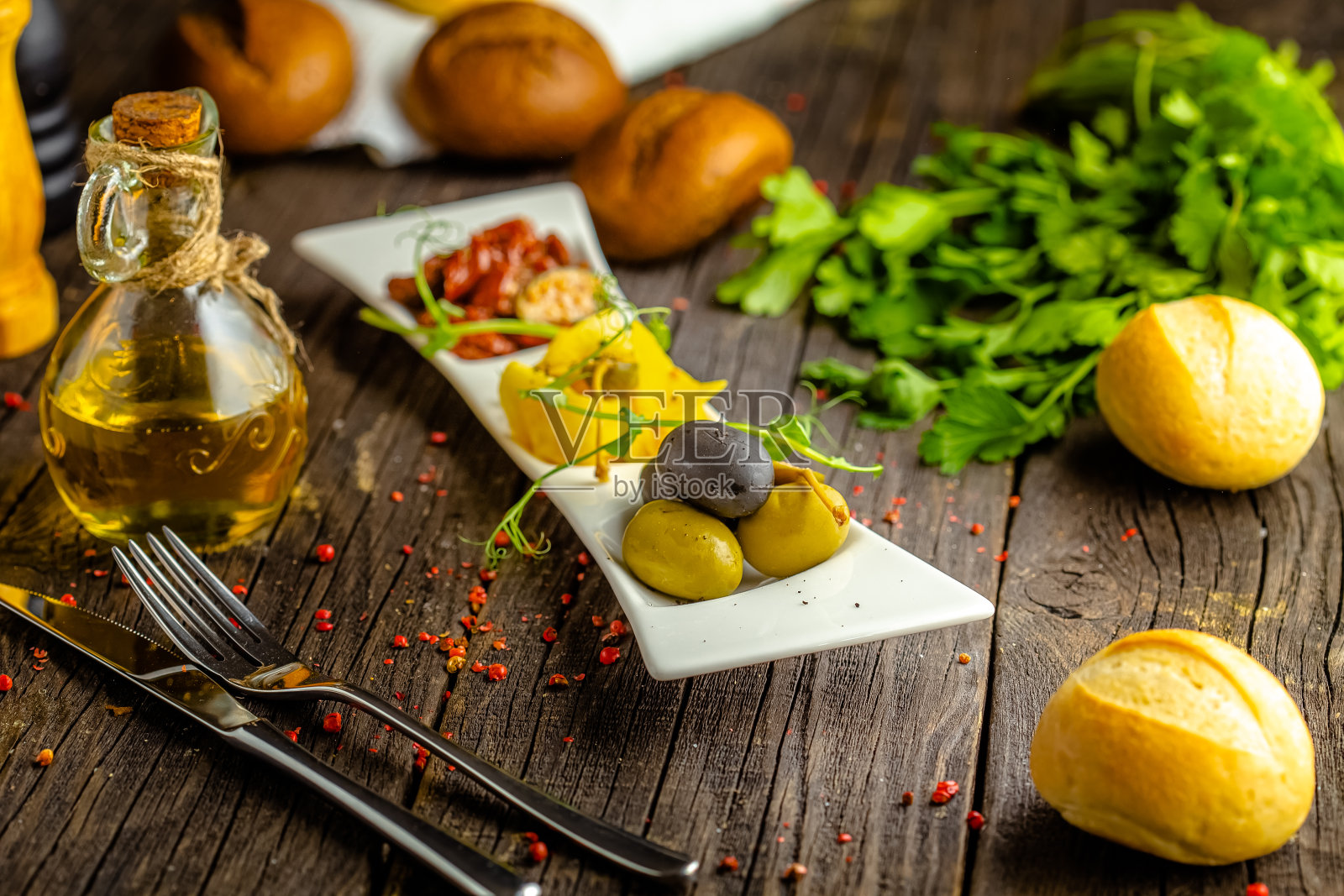 质朴的木制背景，顶部和侧面，在盘子上，开胃酒，大橄榄，晒干的番茄，奶酪和绿色蔬菜照片摄影图片