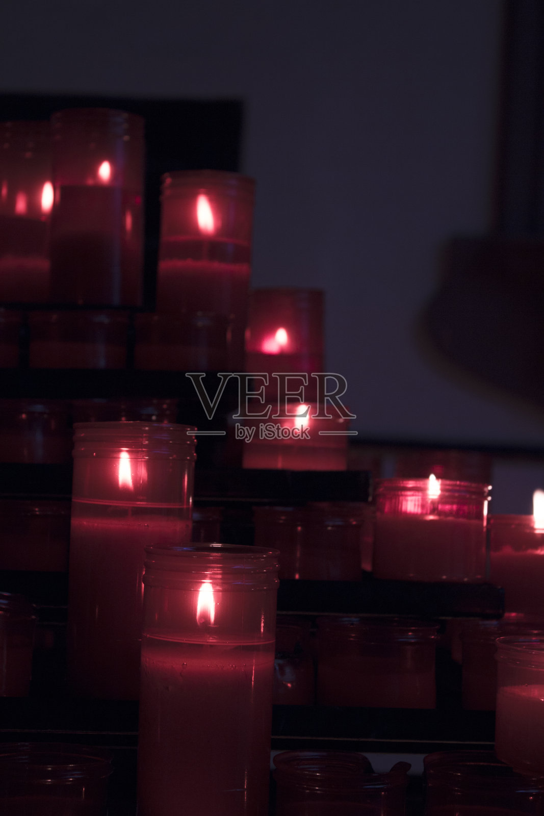 许多燃烧的蜡烛有红色的塑料护套。没有人照片摄影图片