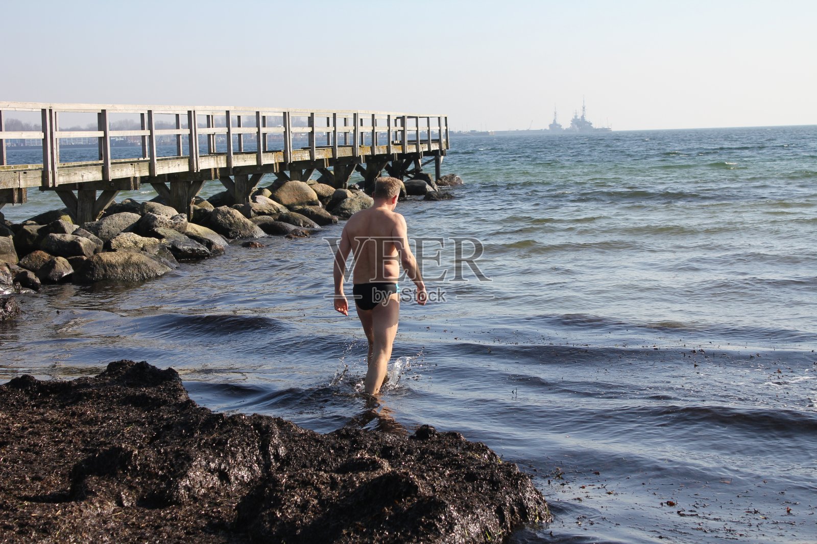 一个男人早晨去海里游泳照片摄影图片