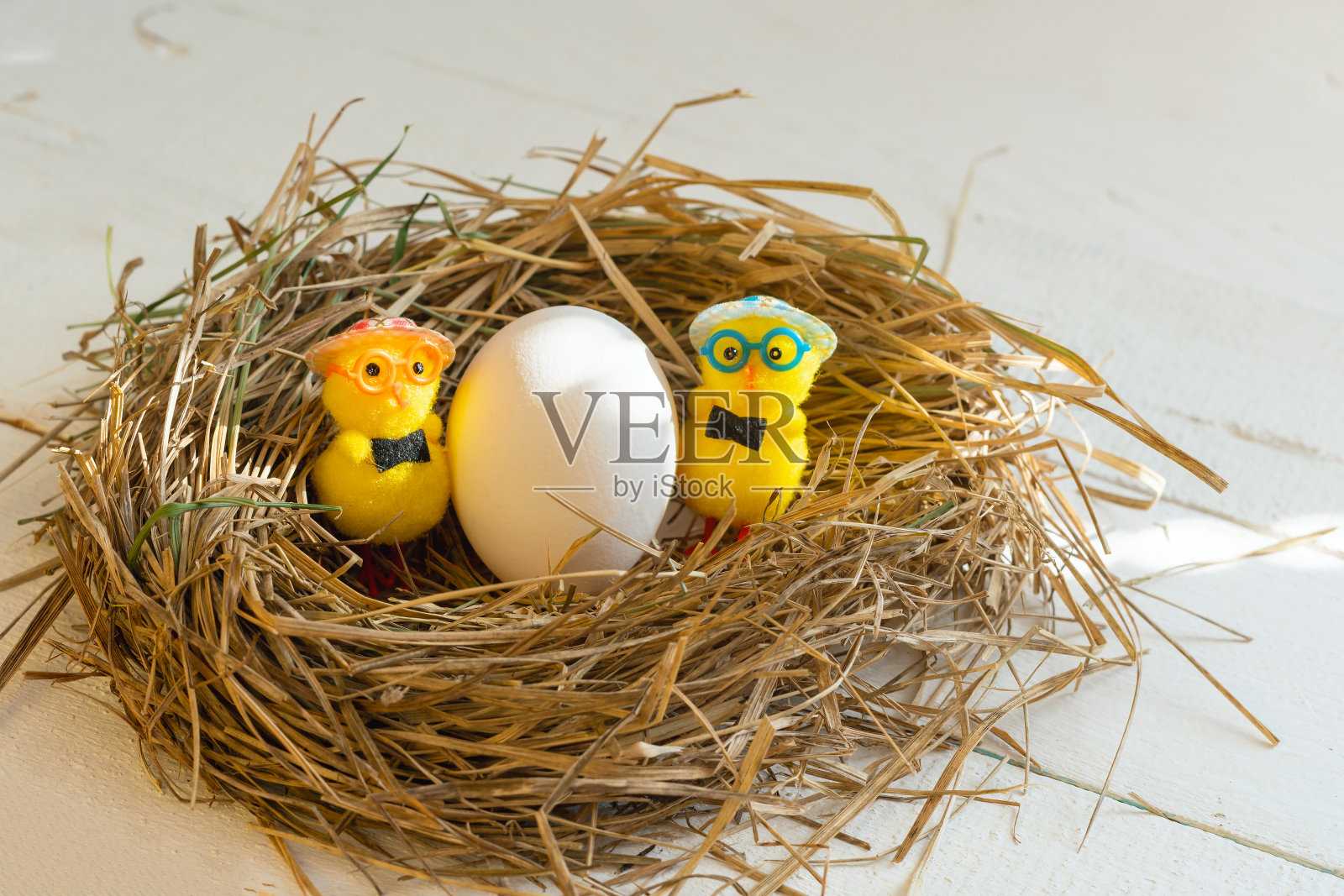 黄色的玩具鸡和蛋在巢里照片摄影图片