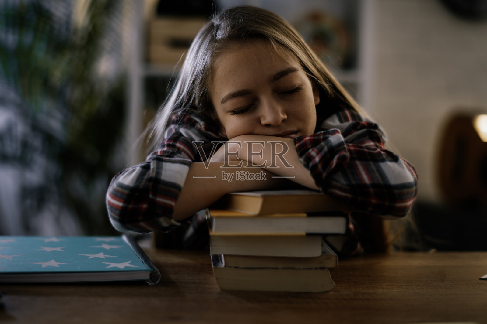 累了的小女孩在家里做作业。照片摄影图片