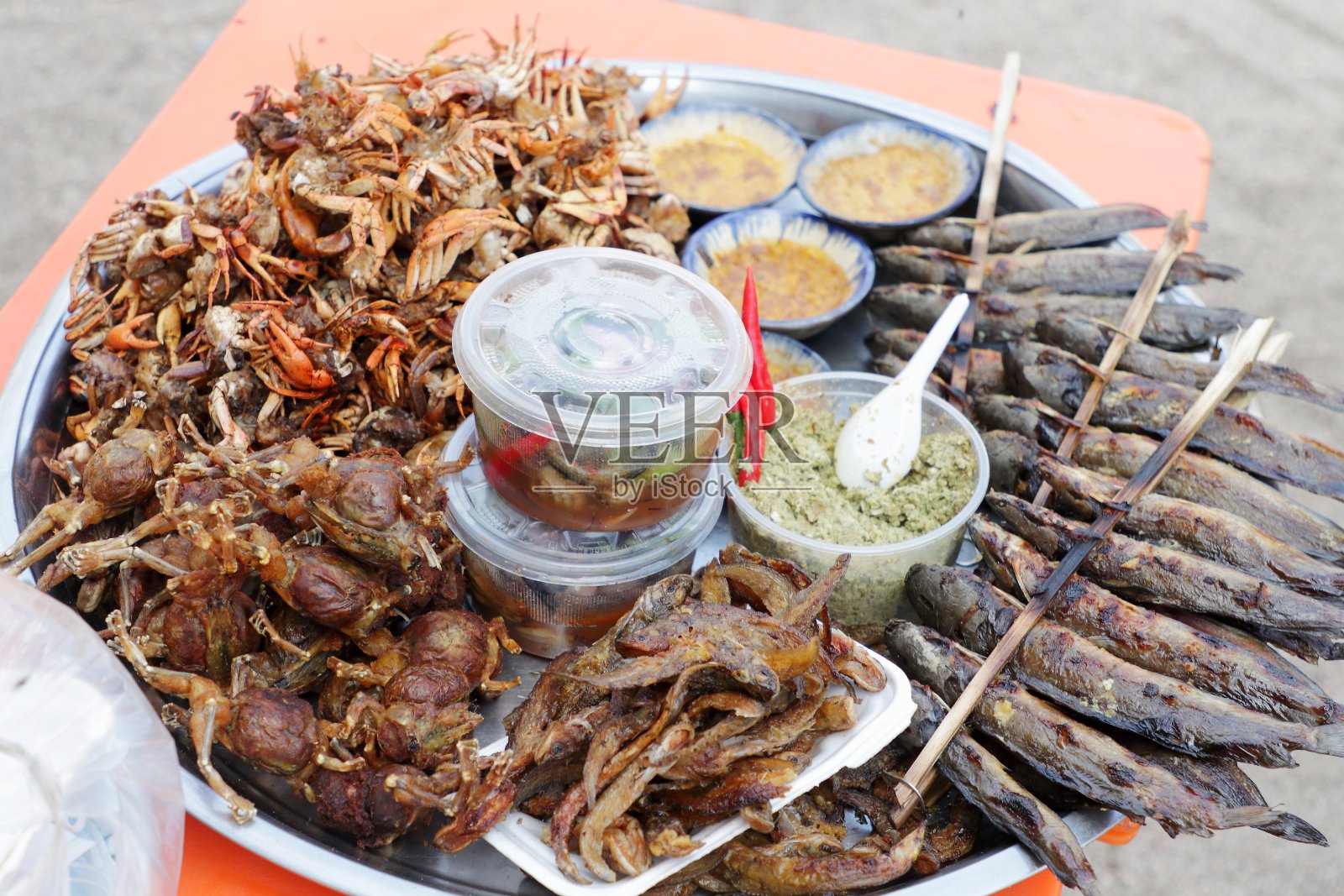 柬埔寨食品市场上出售的一盘烤螃蟹和鱼照片摄影图片