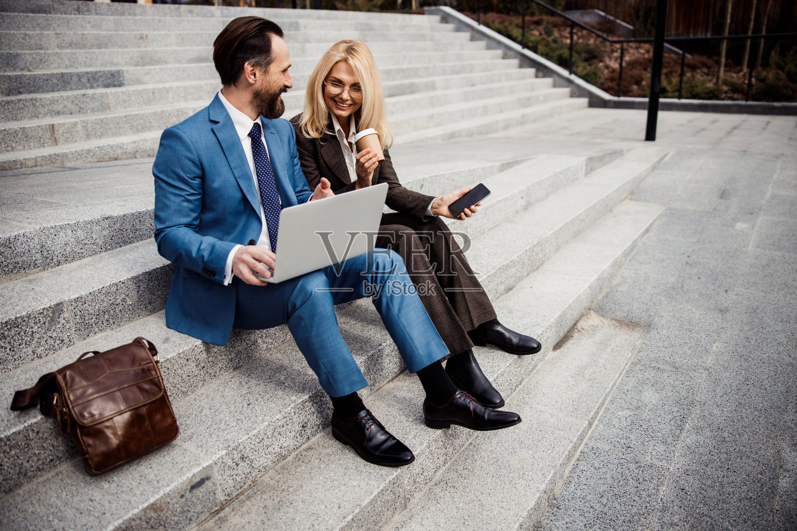 微笑的中年男子看着他的同事照片摄影图片