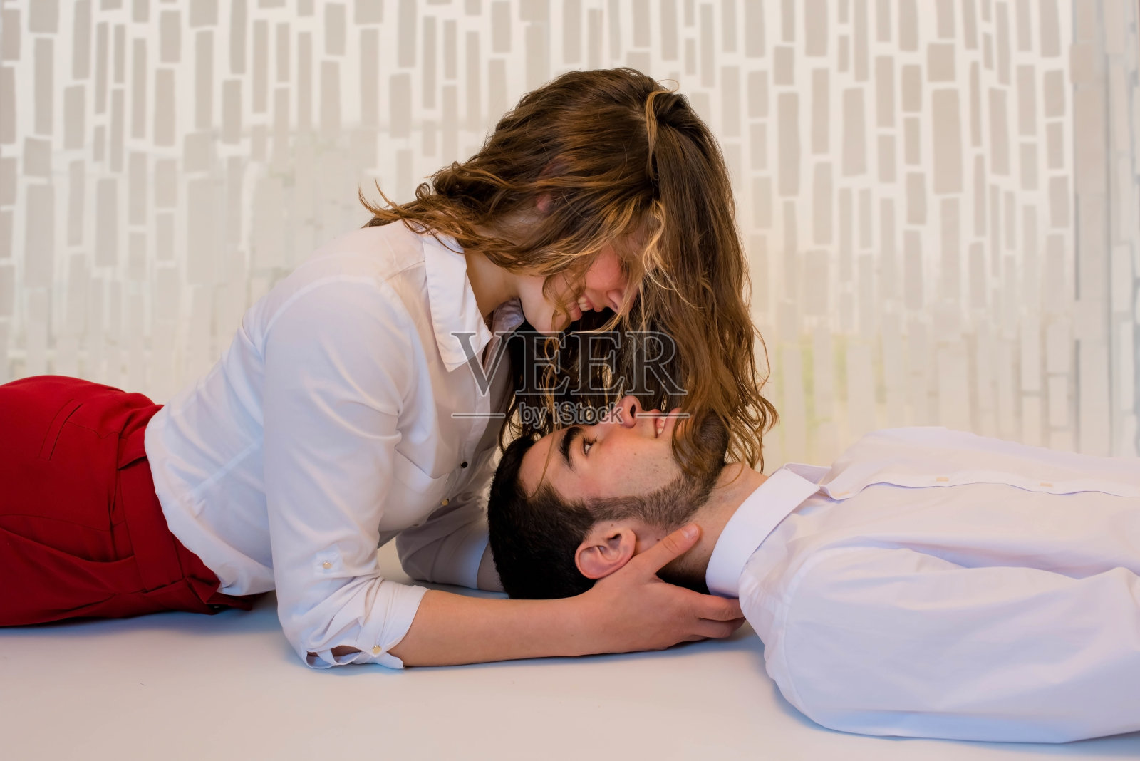 一对年轻情侣接吻的室内肖像照片摄影图片