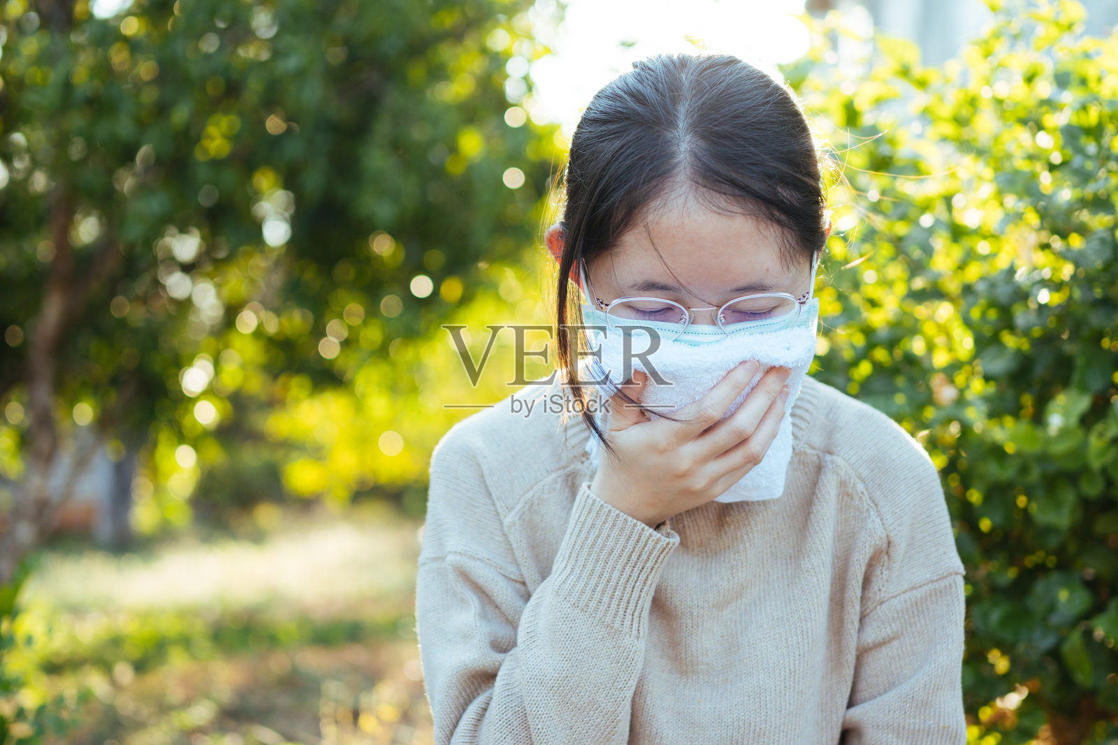 年轻的亚洲青少年戴上防护口罩以防止冠状病毒的传播，并搬到她的家里进行隔离。全球突发卫生事件Covid-19照片摄影图片