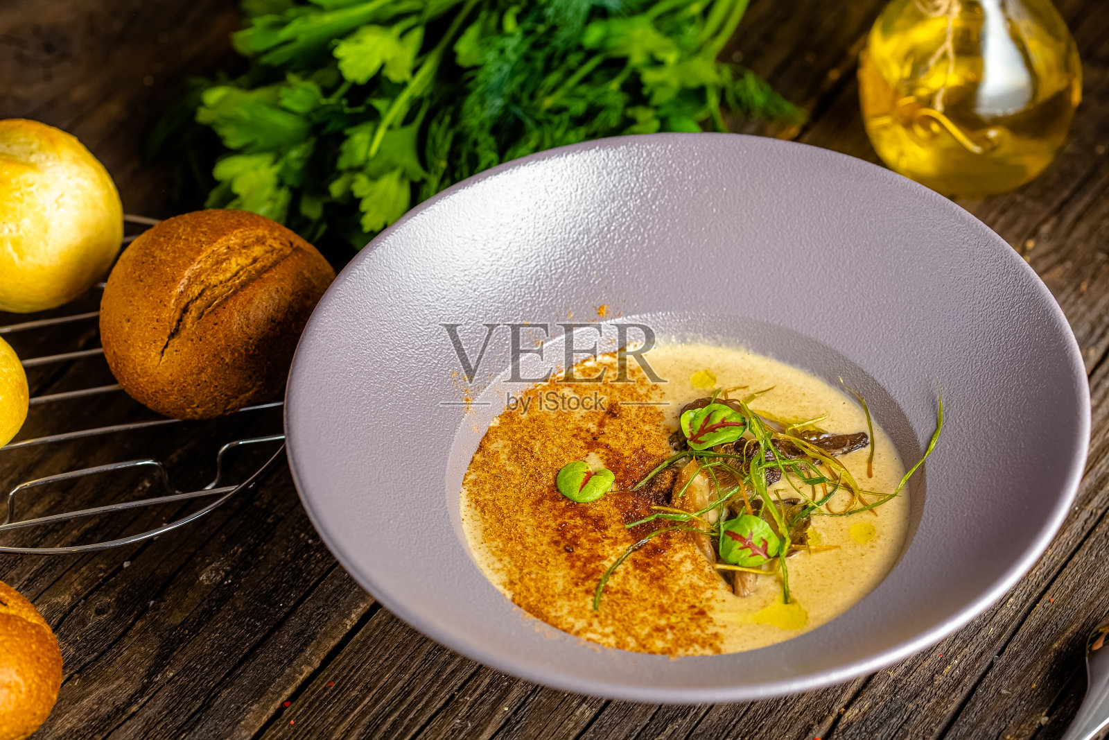 乡村木制背景，顶部和侧面，在一个盘子上，橙棕色蘑菇奶油汤，绿色和蔬菜照片摄影图片