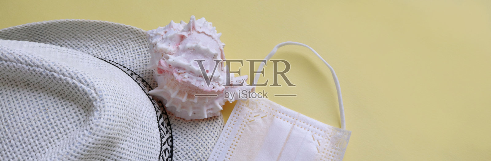 冠状病毒和旅行概念。黄色背景上的暑假和海滩休息标志和呼吸面罩。平躺或俯视图。照片摄影图片