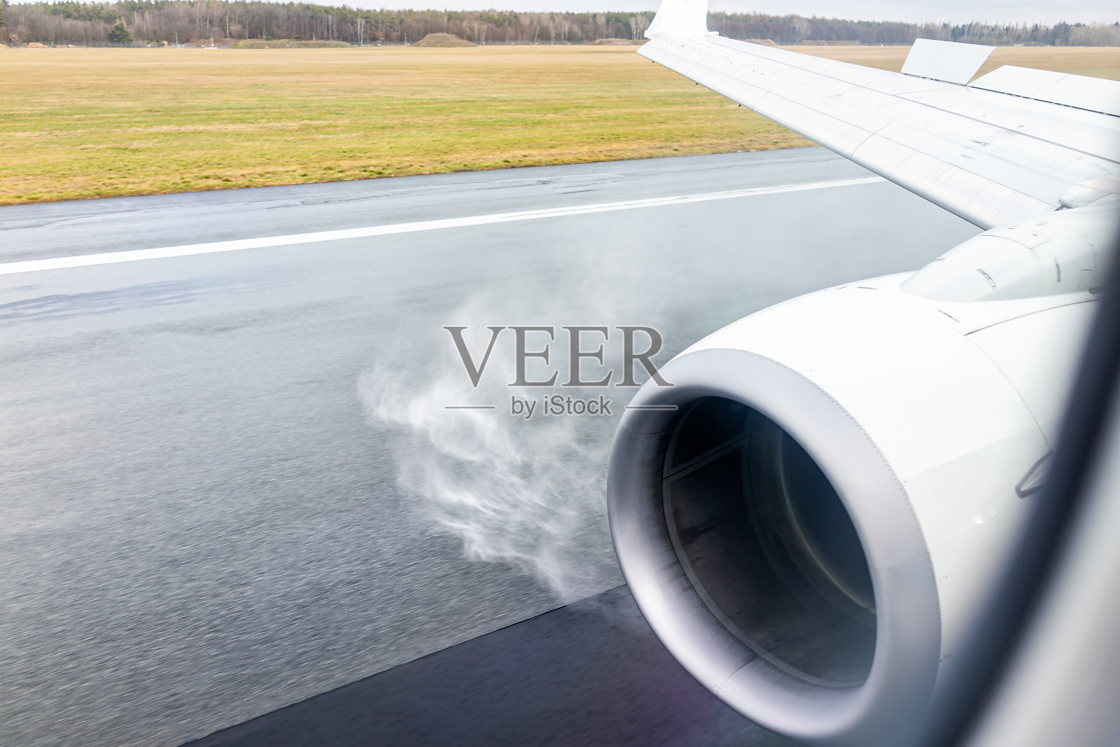现在，波兰华沙附近的Dwor，从窗口降落在机场跑道上，从机翼上看到发动机产生的凝结雾照片摄影图片