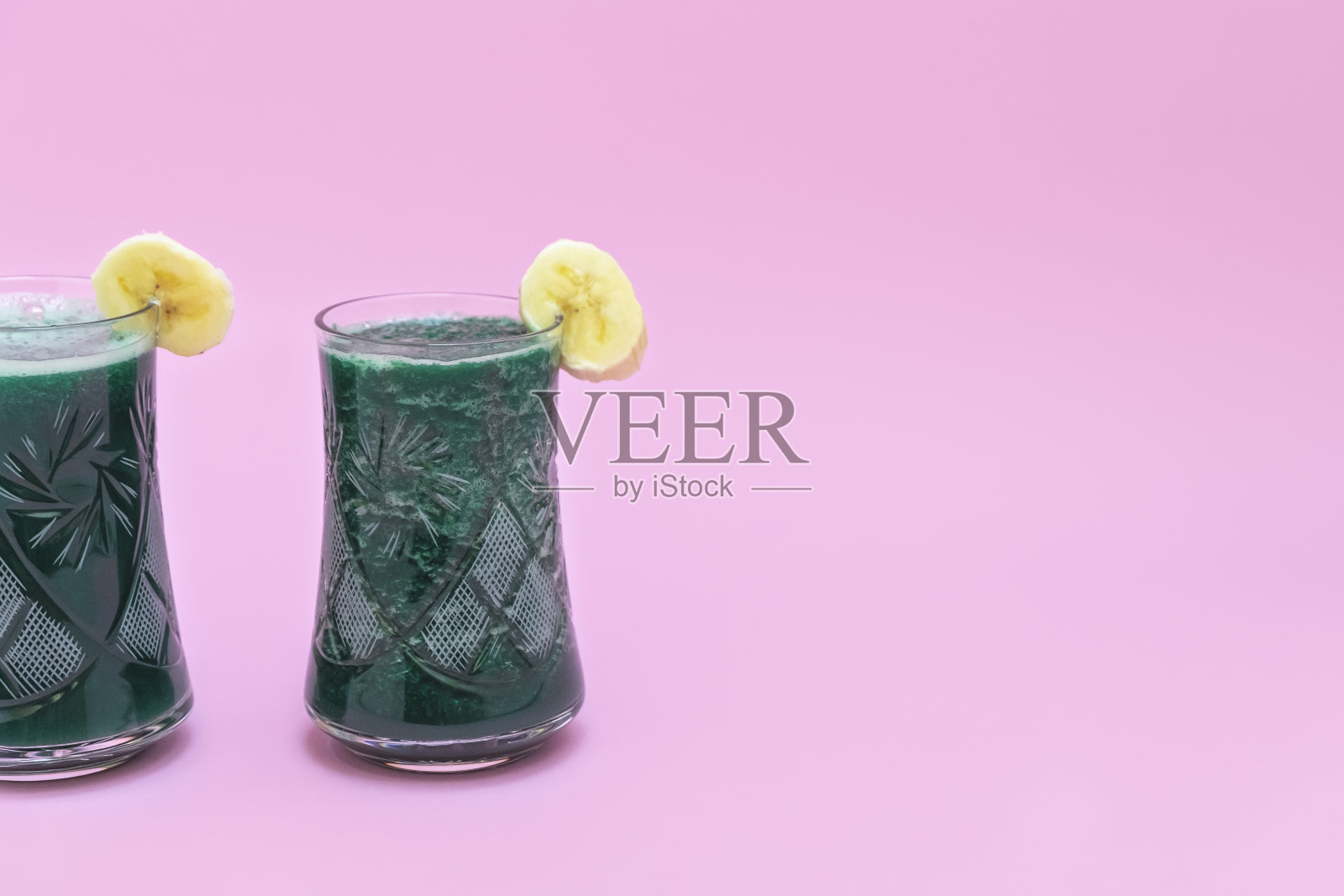 两杯排毒螺旋藻冰沙香蕉软粉色背景与复制空间照片摄影图片