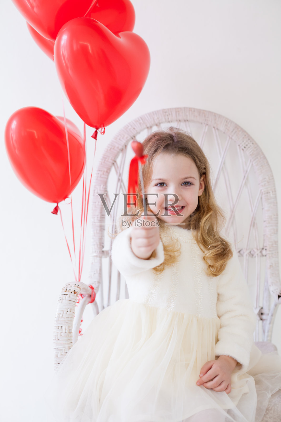 美丽的小女孩带着红色的心形气球度假照片摄影图片