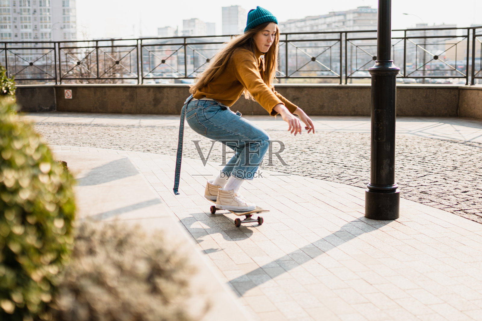 骑着滑板的年轻漂亮的女人。都市风格的运动女性模特肖像。滑板在城市。街头风格的衣服。都市女子骑着滑板。玩滑板的嬉皮士女孩照片摄影图片