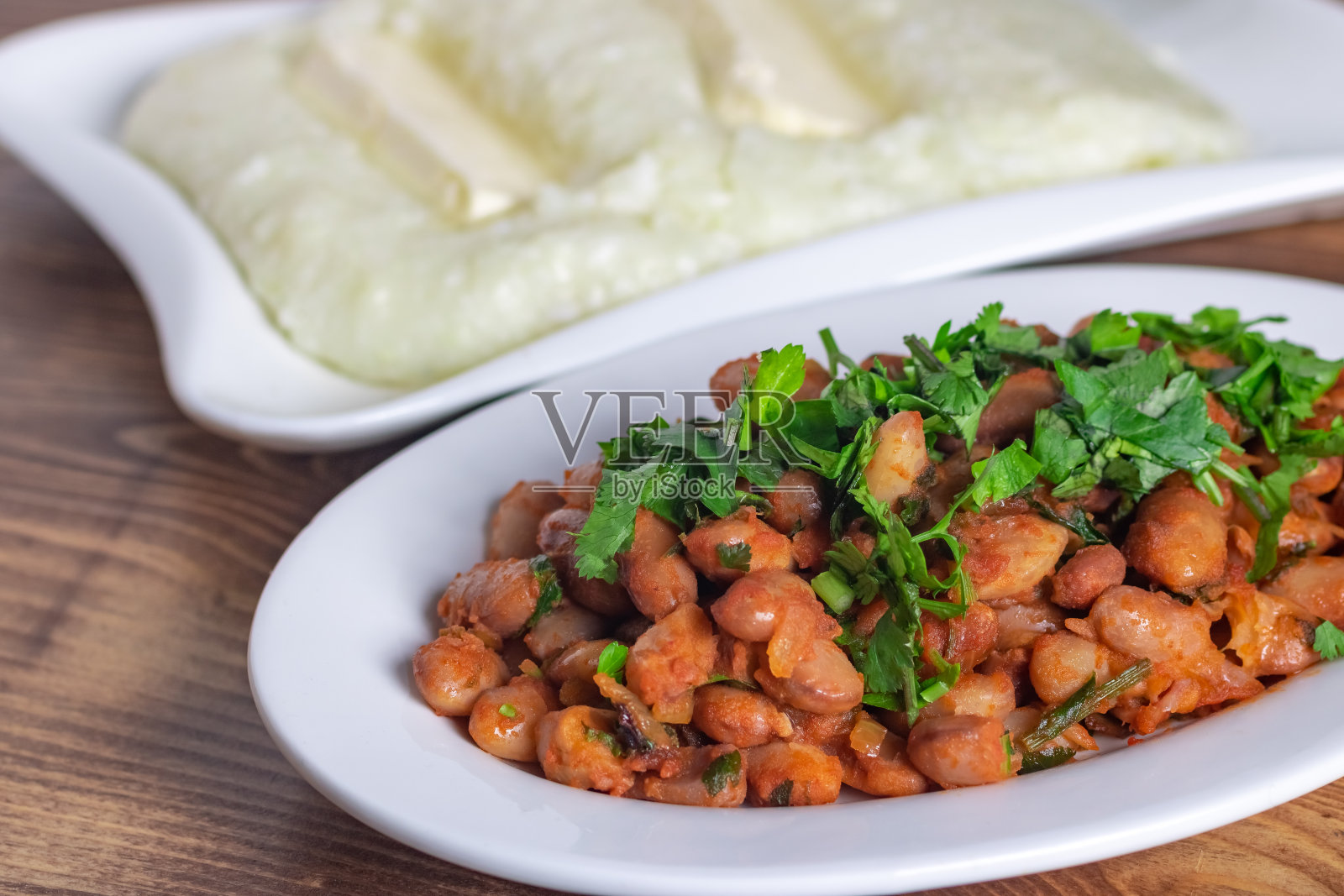 Lobio是一道格鲁吉亚菜，木桌上放着香浓和青葱照片摄影图片