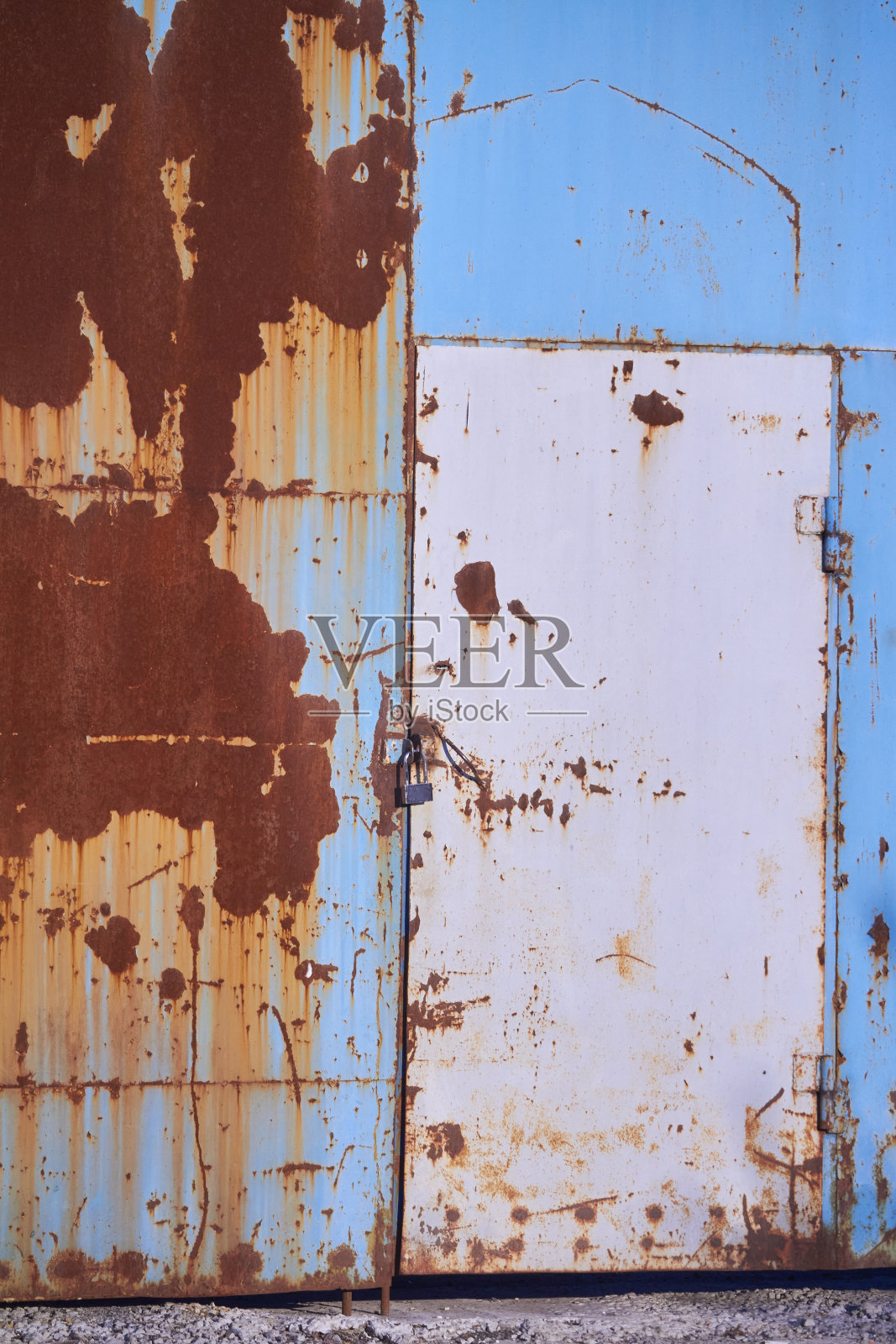 彩色背景，生锈的金属表面与蓝色油漆剥落和金属门挂锁照片摄影图片