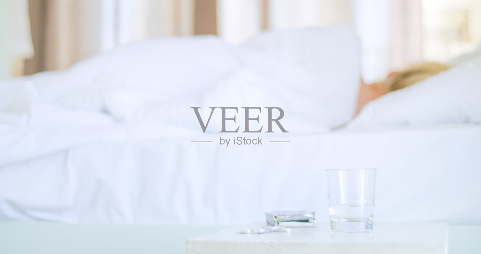 金发女人在床上睡觉，床头柜上有安眠药照片摄影图片