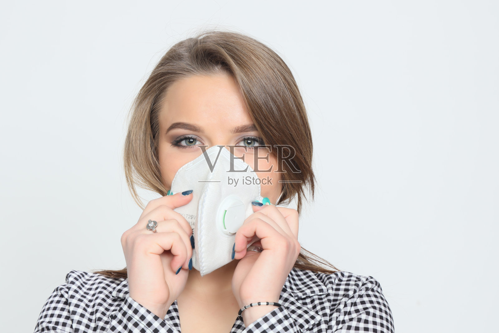 美丽的年轻的黑发女孩戴着防护面具由于冠状病毒。保健理念，预防Covid - 19。照片摄影图片