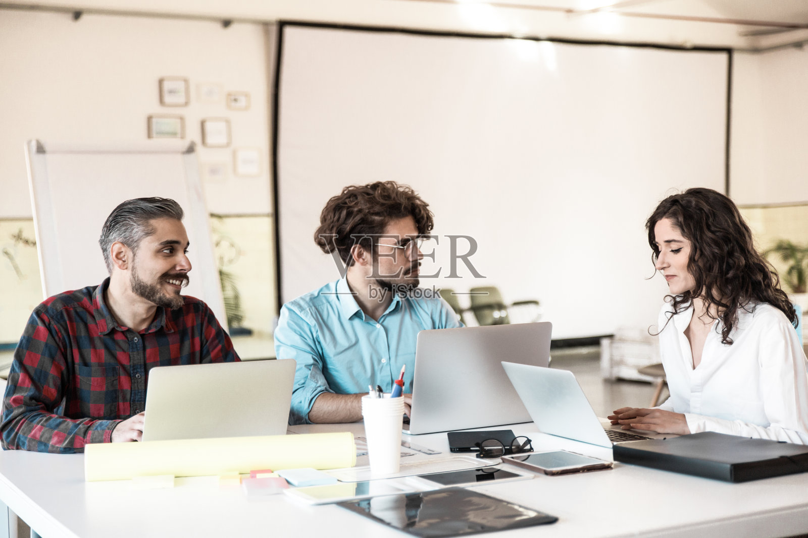 创意小组拿着笔记本电脑在会议室讨论想法照片摄影图片