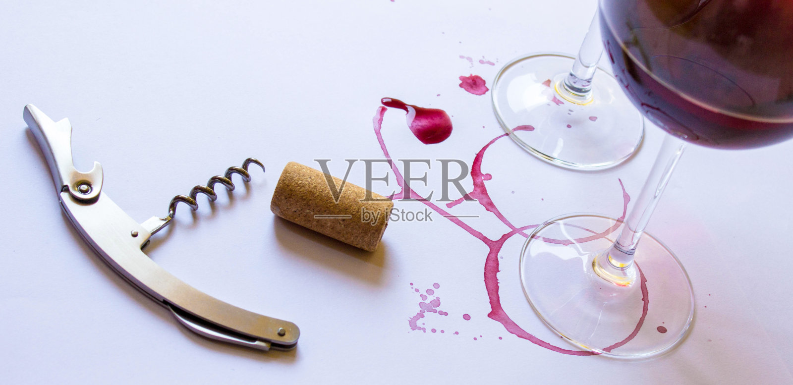 两杯粉红红酒，开瓶器，开瓶器，白色背景，有葡萄酒的痕迹。照片摄影图片