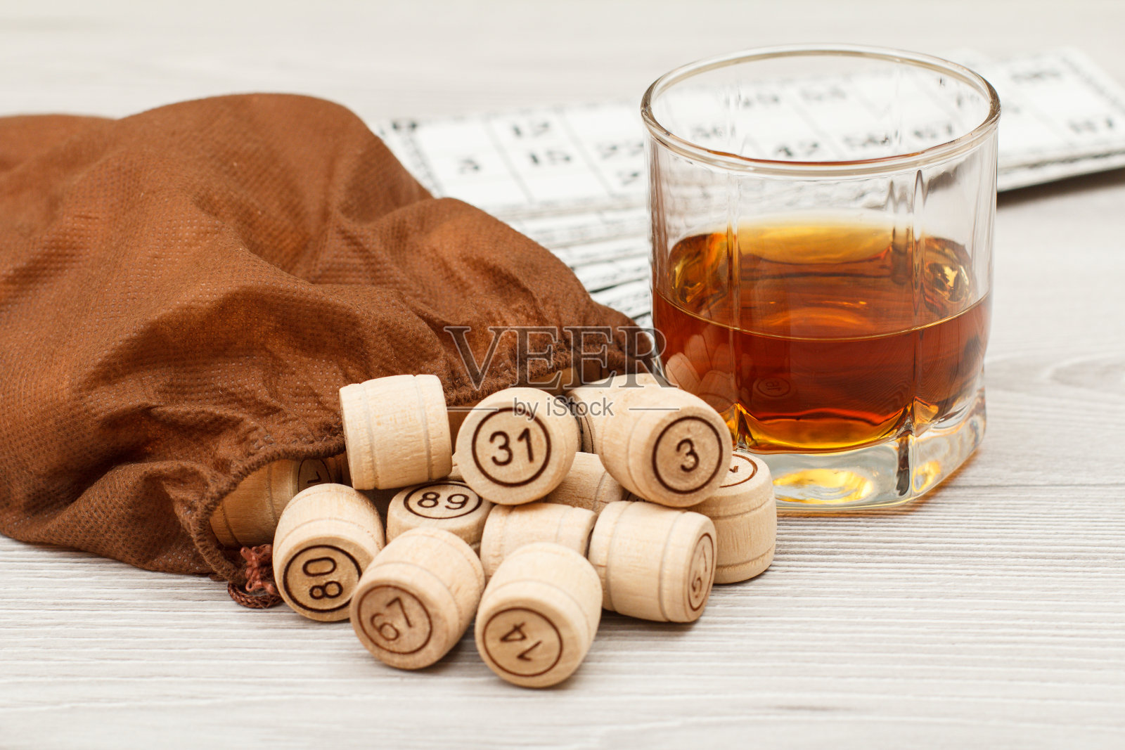 木桌上放着彩票和一杯威士忌照片摄影图片