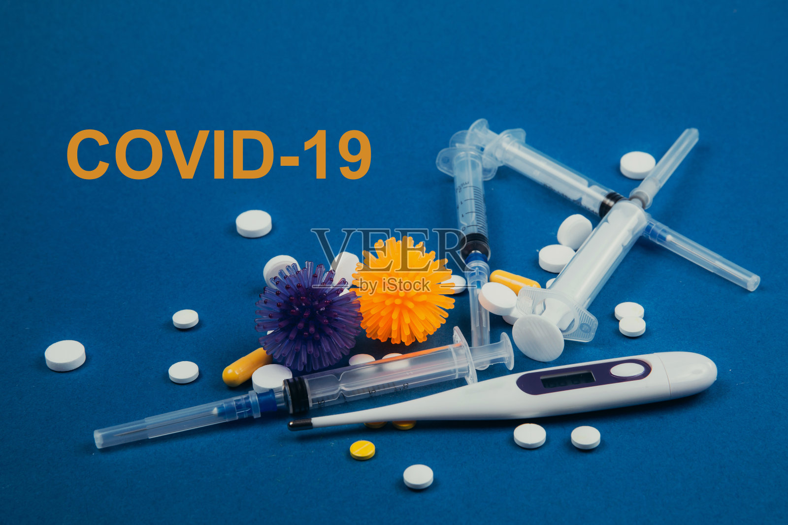 温度计，注射器，抽象病毒模型和药片在蓝色背景照片摄影图片