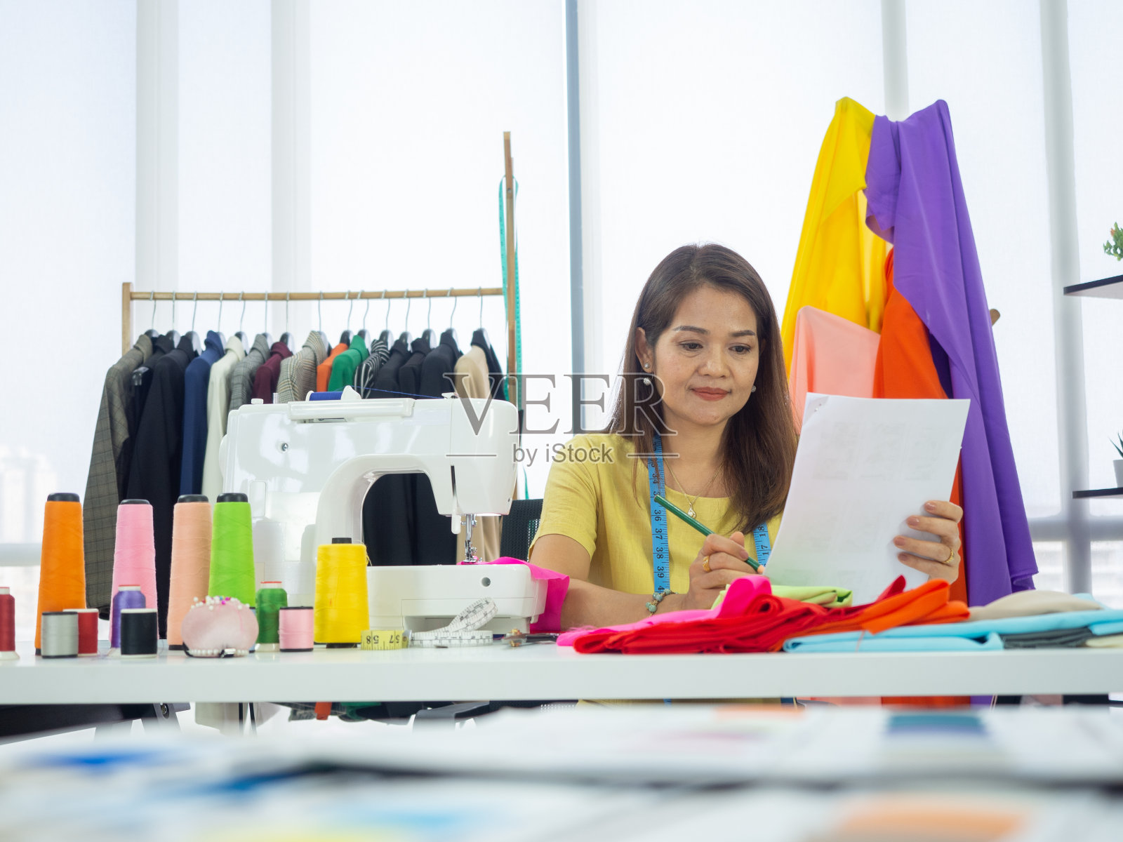 快乐微笑的亚洲创意时装设计师正在工作的业主，裁缝，裁缝店。照片摄影图片