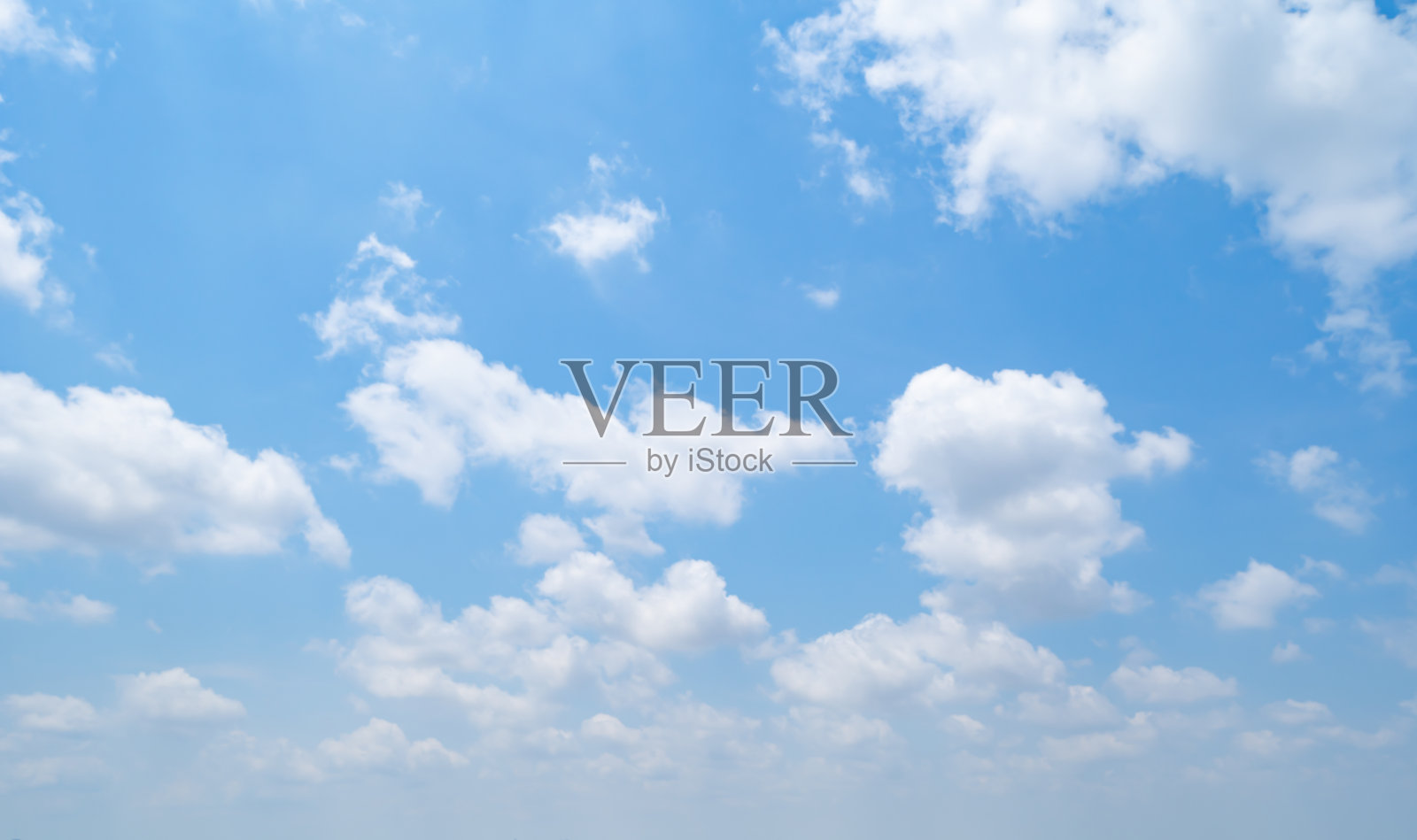 中午晴空万里，白云飘飘。一天的时间。抽象的自然景观背景。照片摄影图片