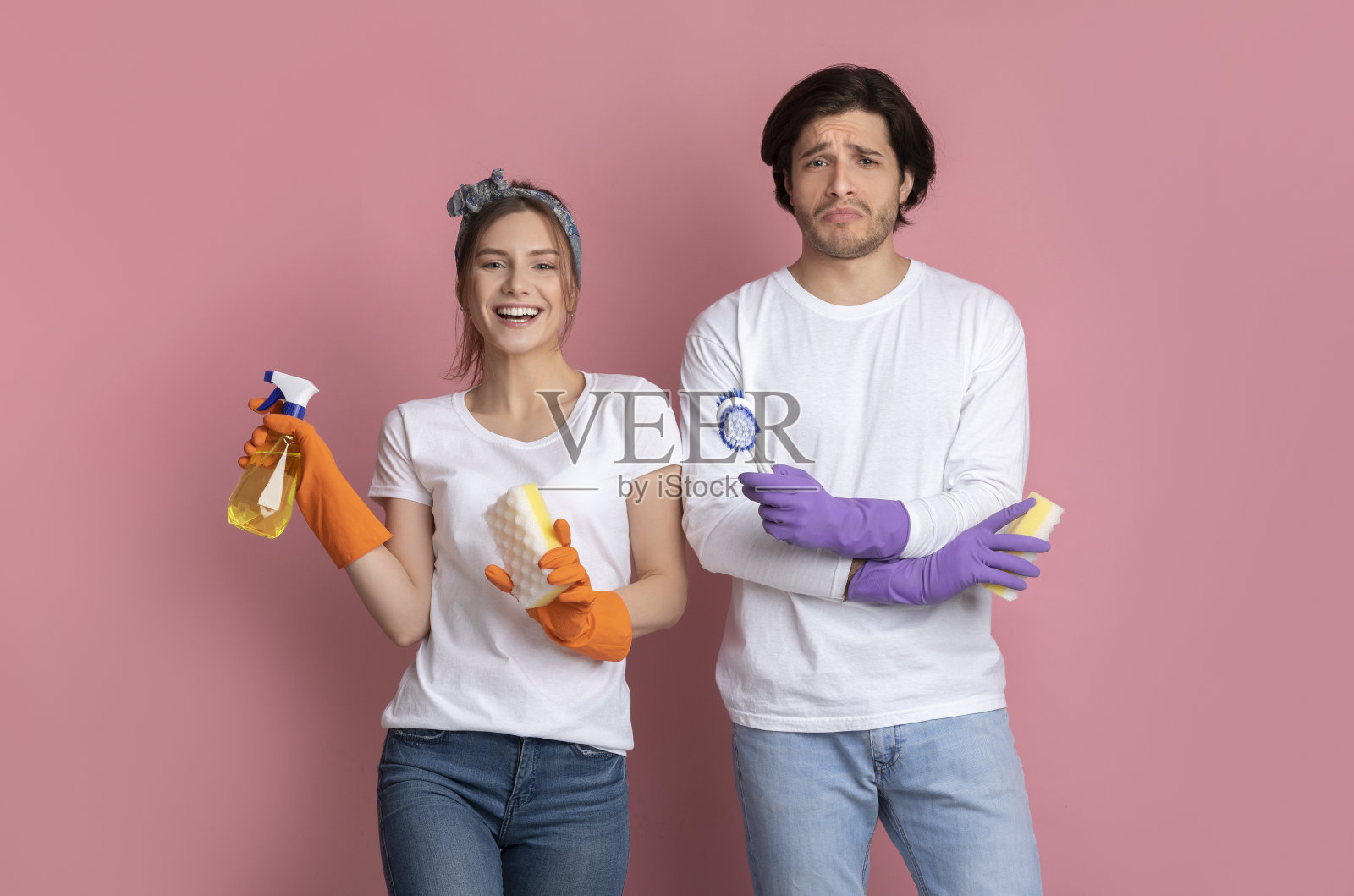 家庭职责。心烦意乱的男人手里拿着刷子靠近快乐的女友照片摄影图片