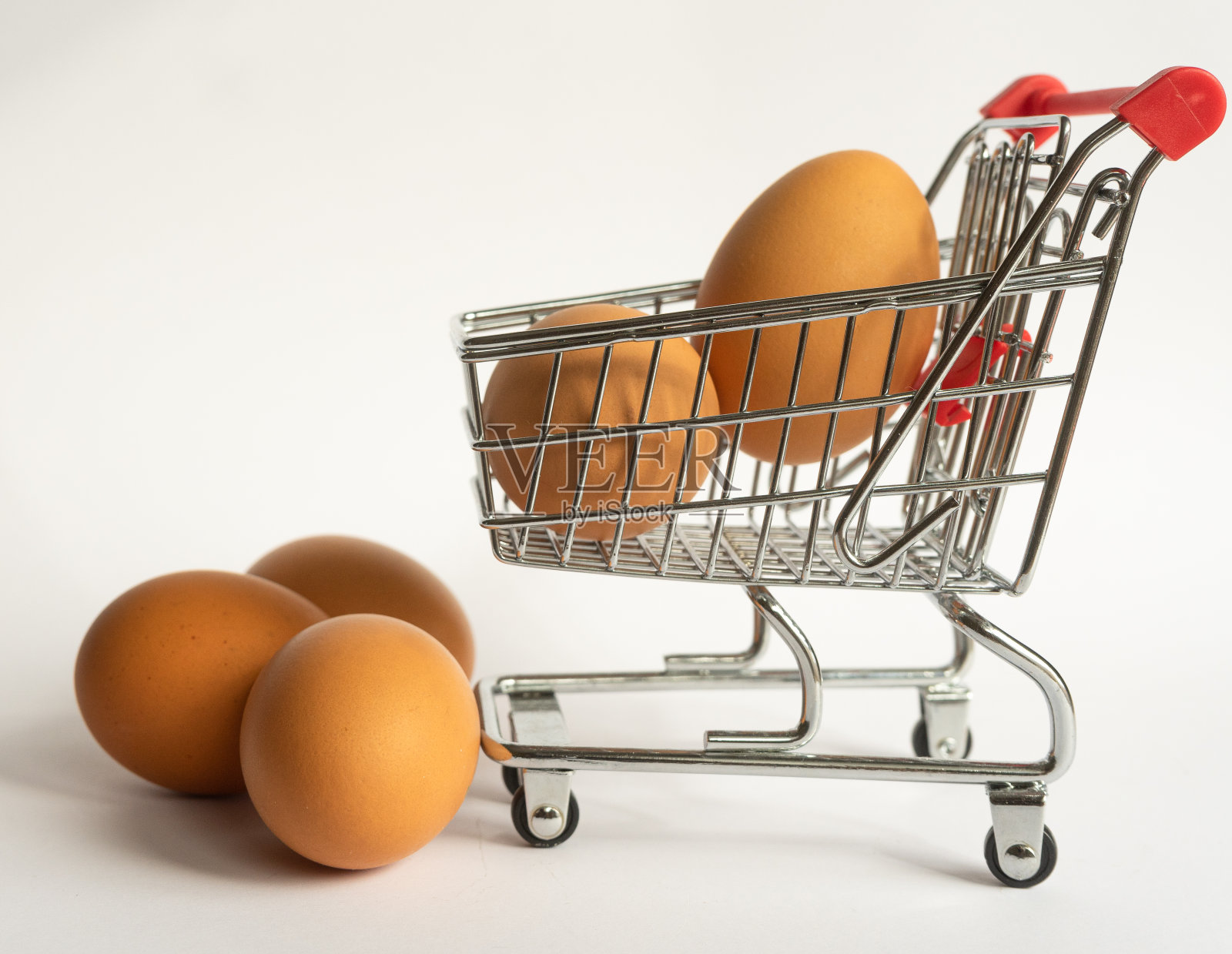小玩具食品推车，钢制，红色塑料把手，灰色背景，五个新鲜鸡蛋。空的空间照片摄影图片