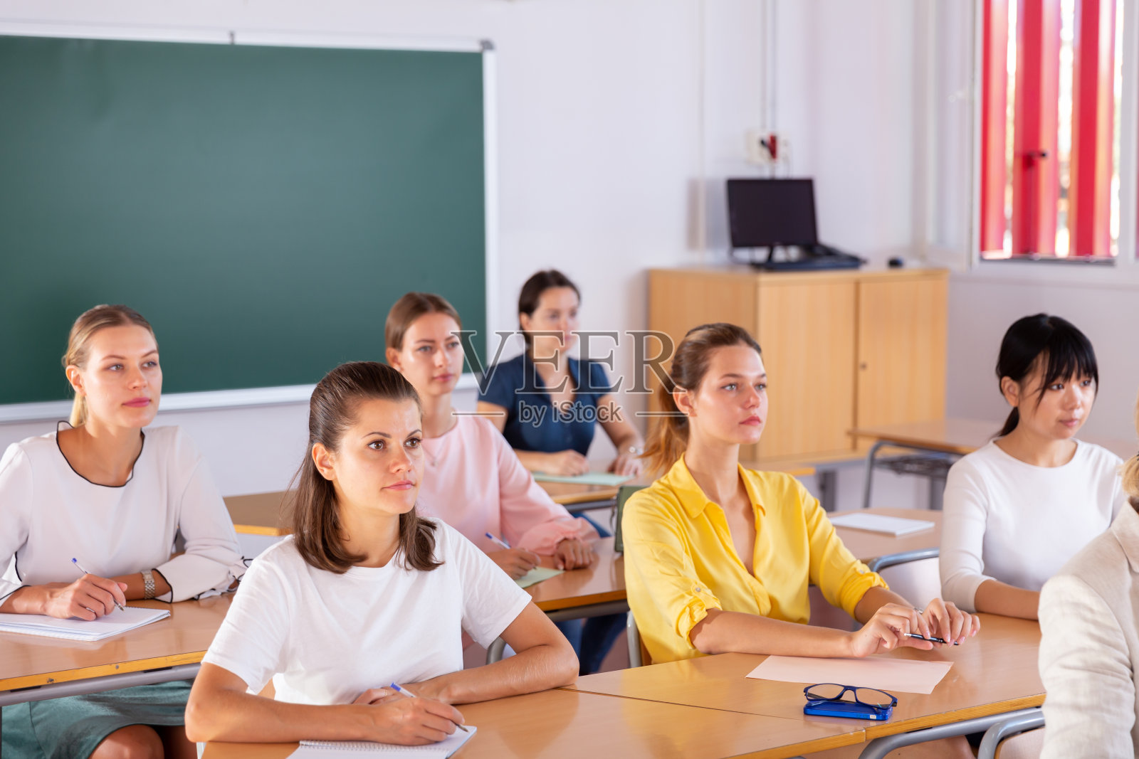 学生们在上课时在笔记本上写作照片摄影图片