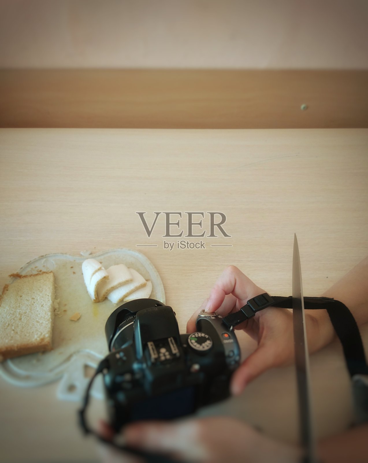 一个女孩在给食物拍照，但有人试图用刀砍断她的手照片摄影图片