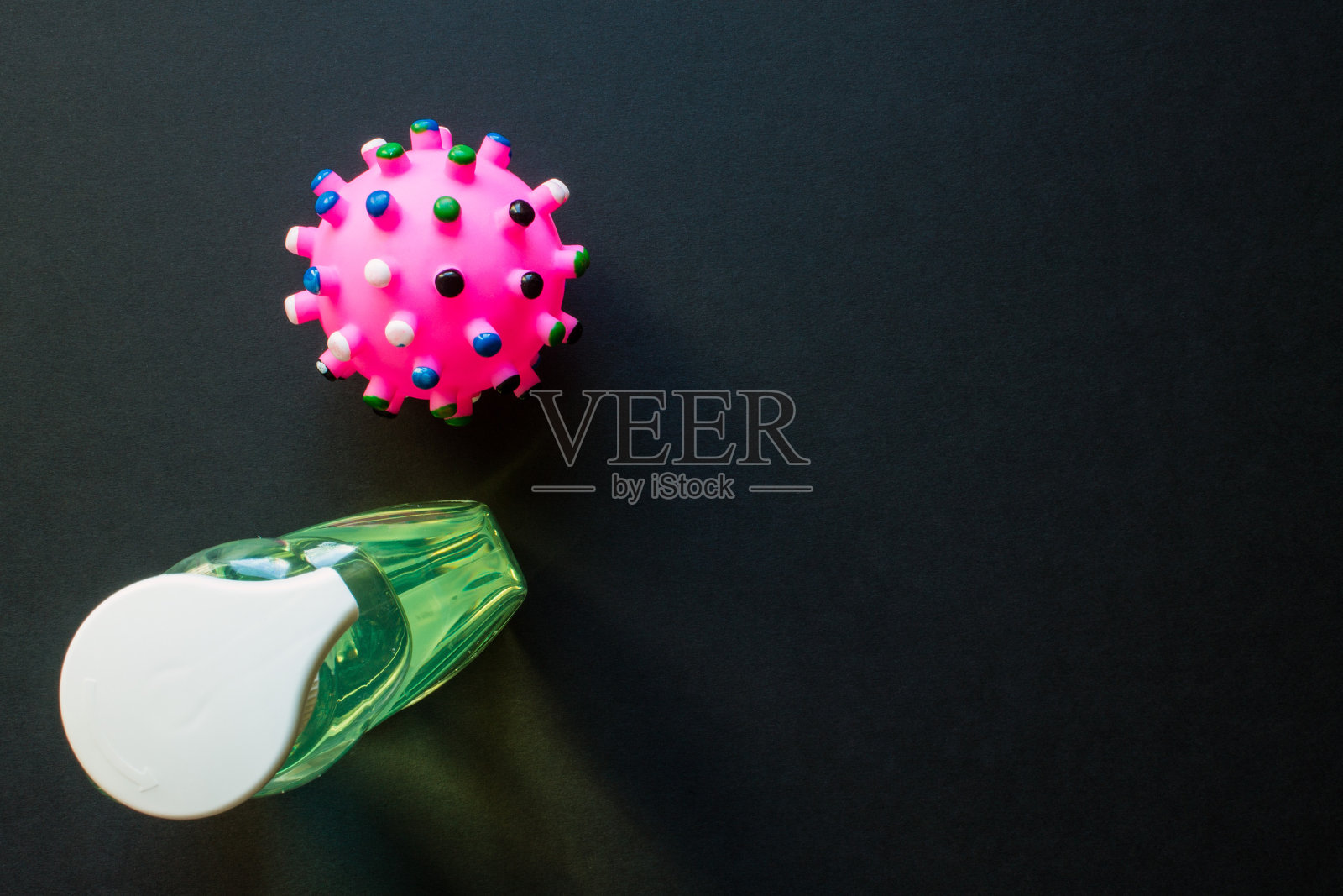 一瓶液体肥皂和一个粉红色的冠状病毒分子照片摄影图片