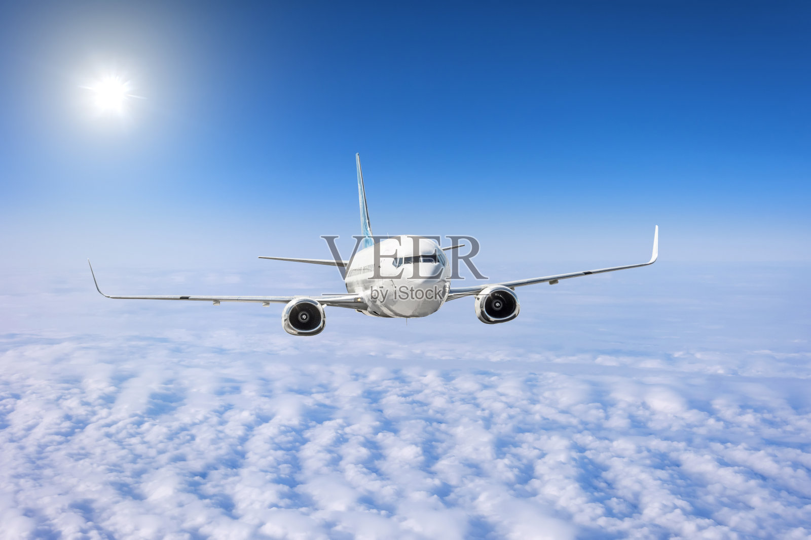 客机飞过云雾，灿烂的阳光照耀着天空。照片摄影图片