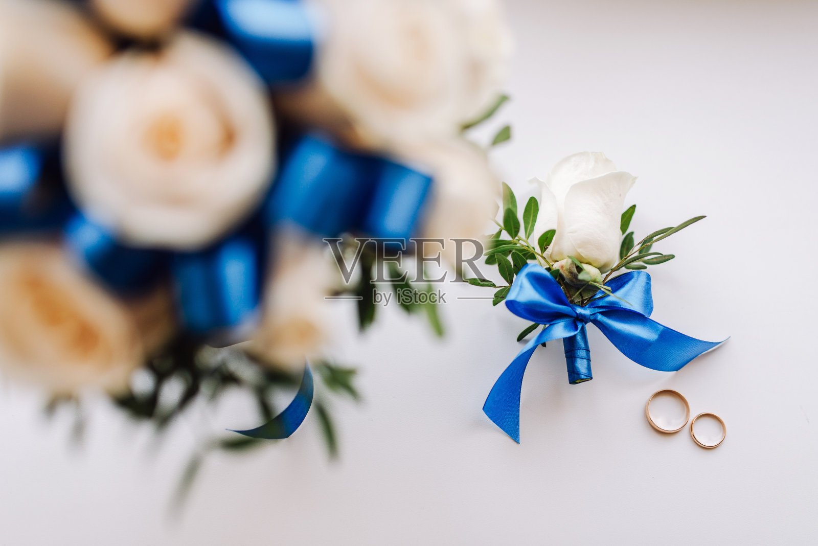 婚礼新娘捧花，新郎和新娘的结婚戒指，新郎的u2019胸花。顶视图的布局。婚礼的背景照片摄影图片