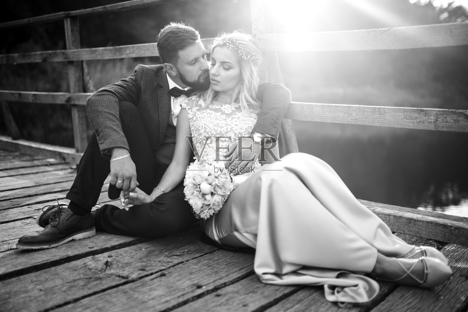 一对优雅的新婚夫妇在婚礼当天在一座桥上摆姿势。照片摄影图片