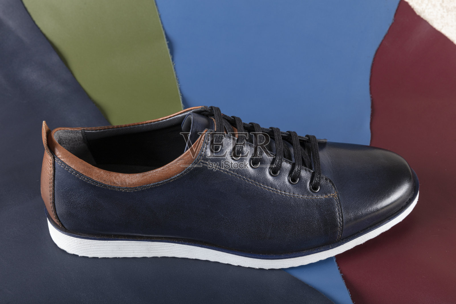 彩色皮革上的皮鞋。以彩色皮革为背景的男士时装秀。照片摄影图片