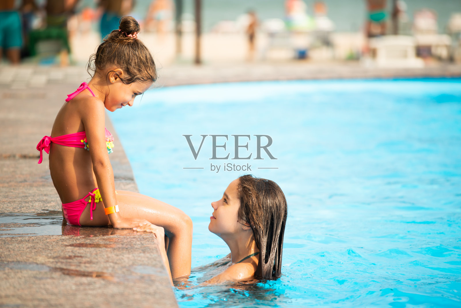 侧视图小女孩姐妹们在游泳池游泳照片摄影图片