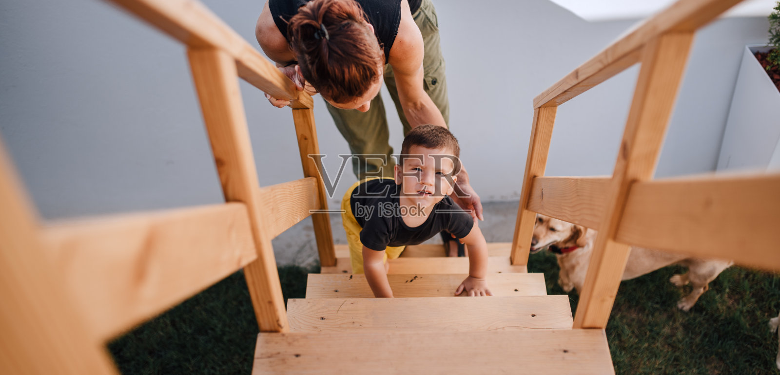 幼儿男孩爬上树屋的楼梯照片摄影图片