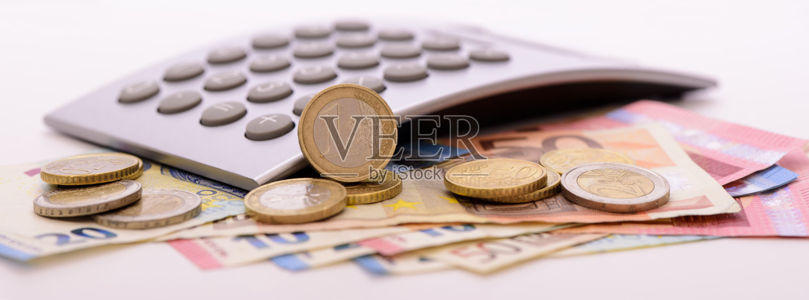 一堆带有硬币和计算器的欧元纸币照片摄影图片