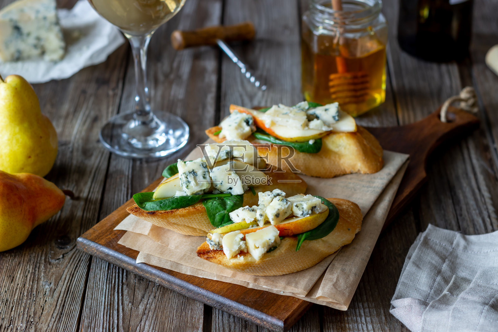 意式烤面包配菠菜、梨和蓝奶酪。葡萄酒。素食。健康饮食。纯素食主义。饮食。照片摄影图片