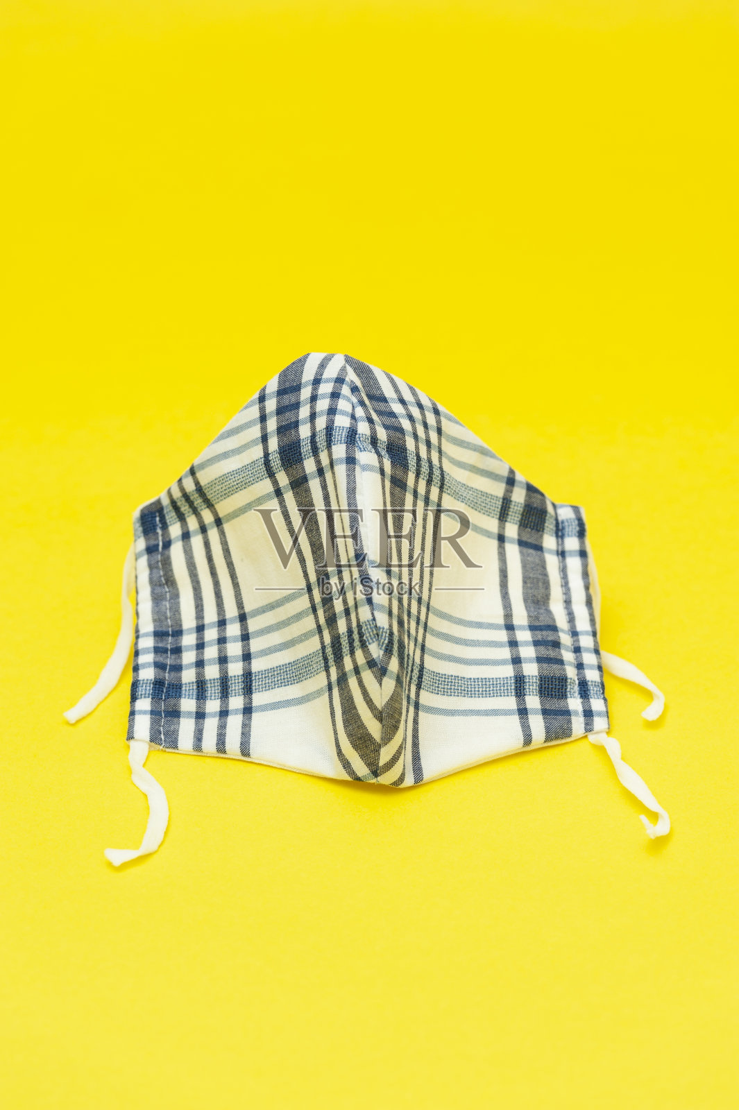 蓝白(DIY)自制防护新型冠状病毒(COVID-19)布口罩垂直拍摄。照片摄影图片