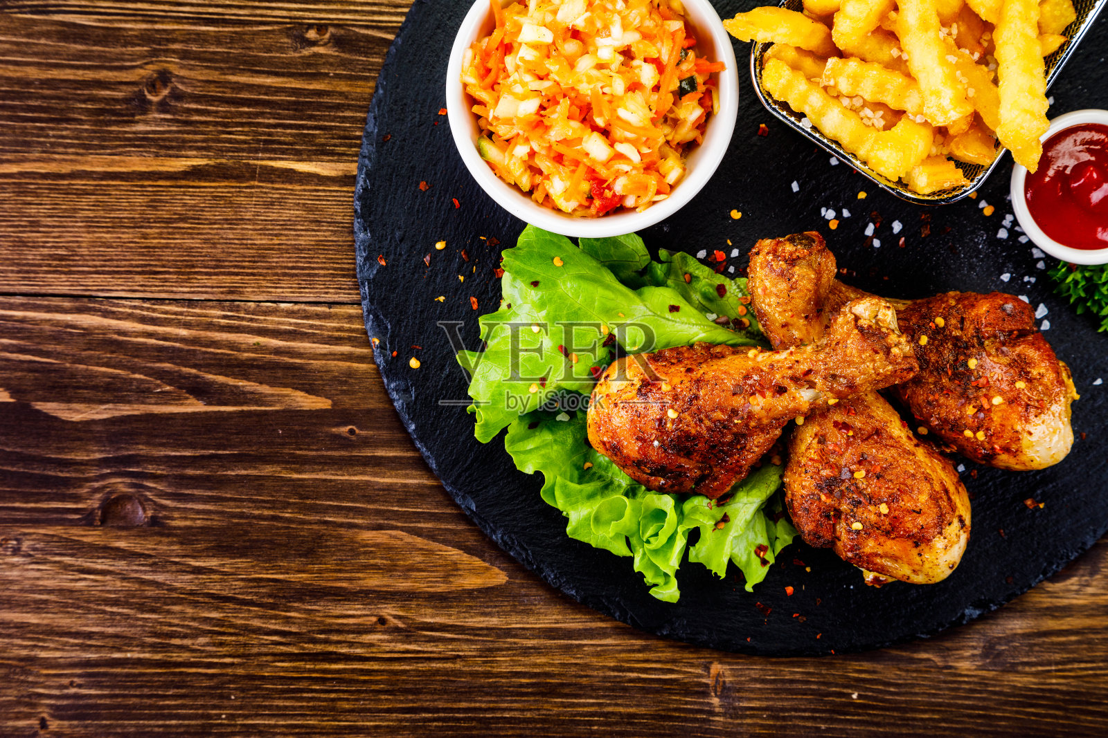 烤鸡腿和蔬菜放在砧板上照片摄影图片