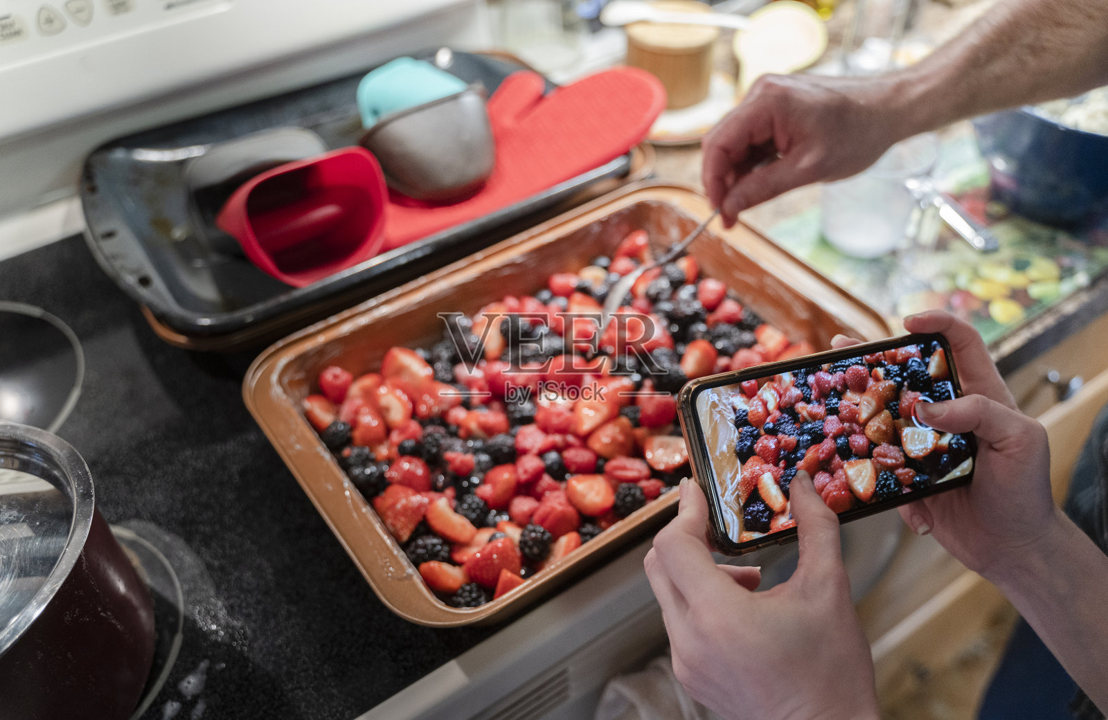 一个十几岁的女孩在用智能手机拍她装馅饼的照片。照片摄影图片