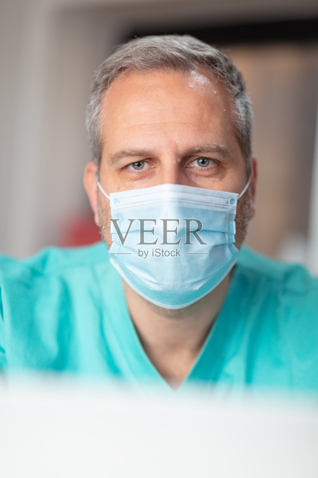 身穿医疗保健制服的中年男人戴着防护口罩照片摄影图片
