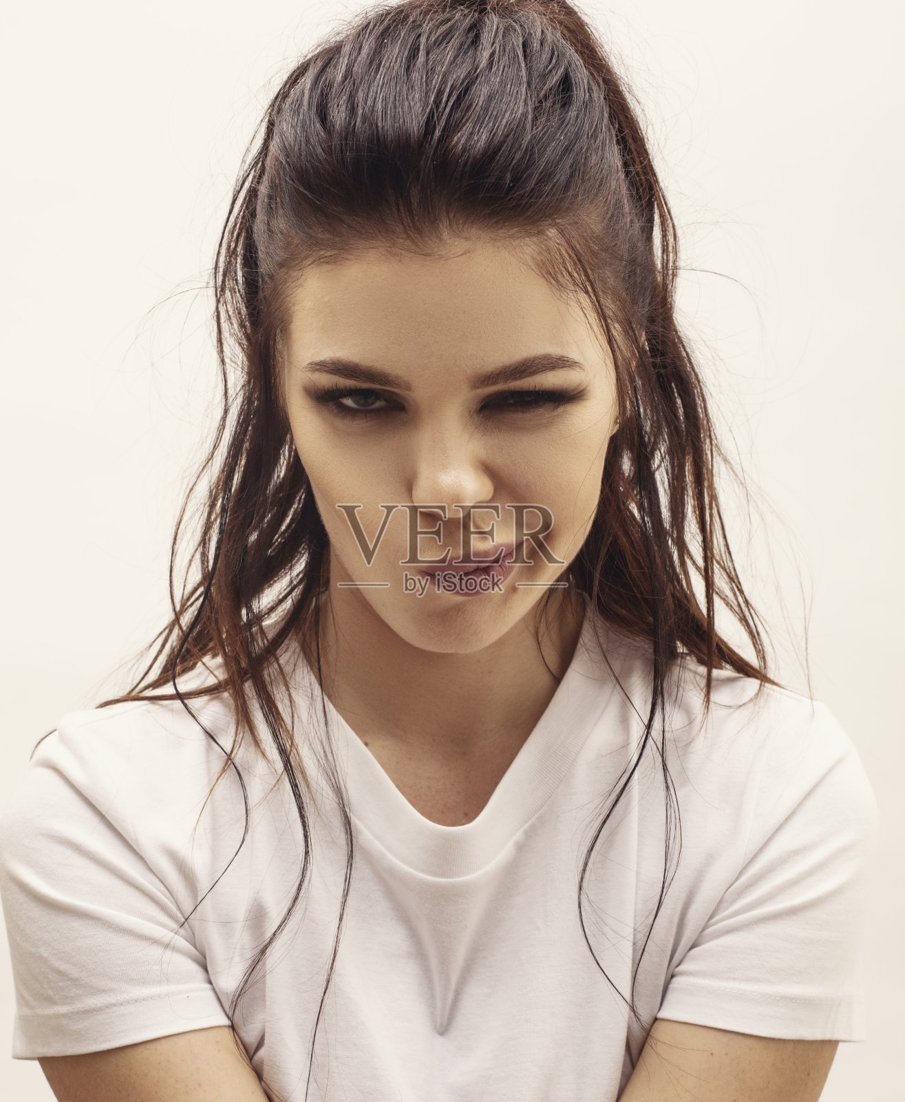 美丽活泼的女人在白色的背景前眨眼照片摄影图片