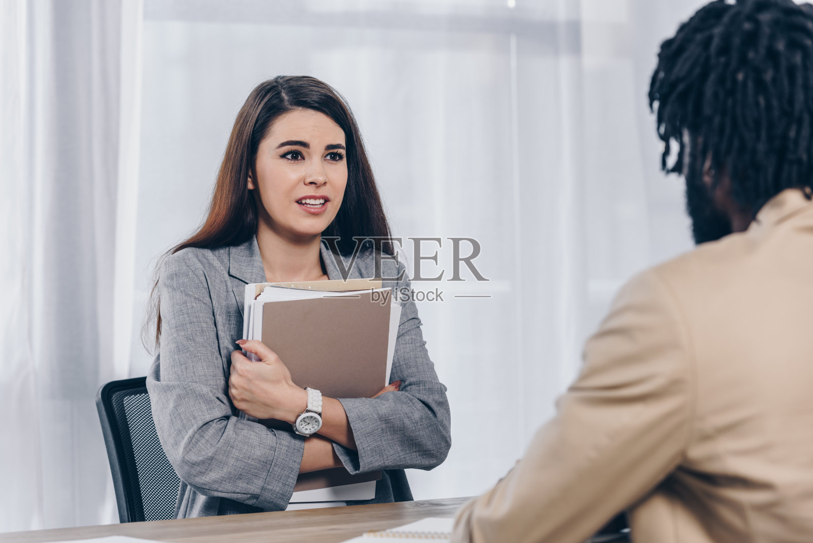 在办公室面试时，忧心忡忡的员工和非裔美国招聘者互相看着对方照片摄影图片